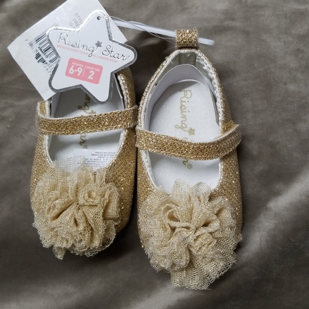Baby shoes with pom poms on top